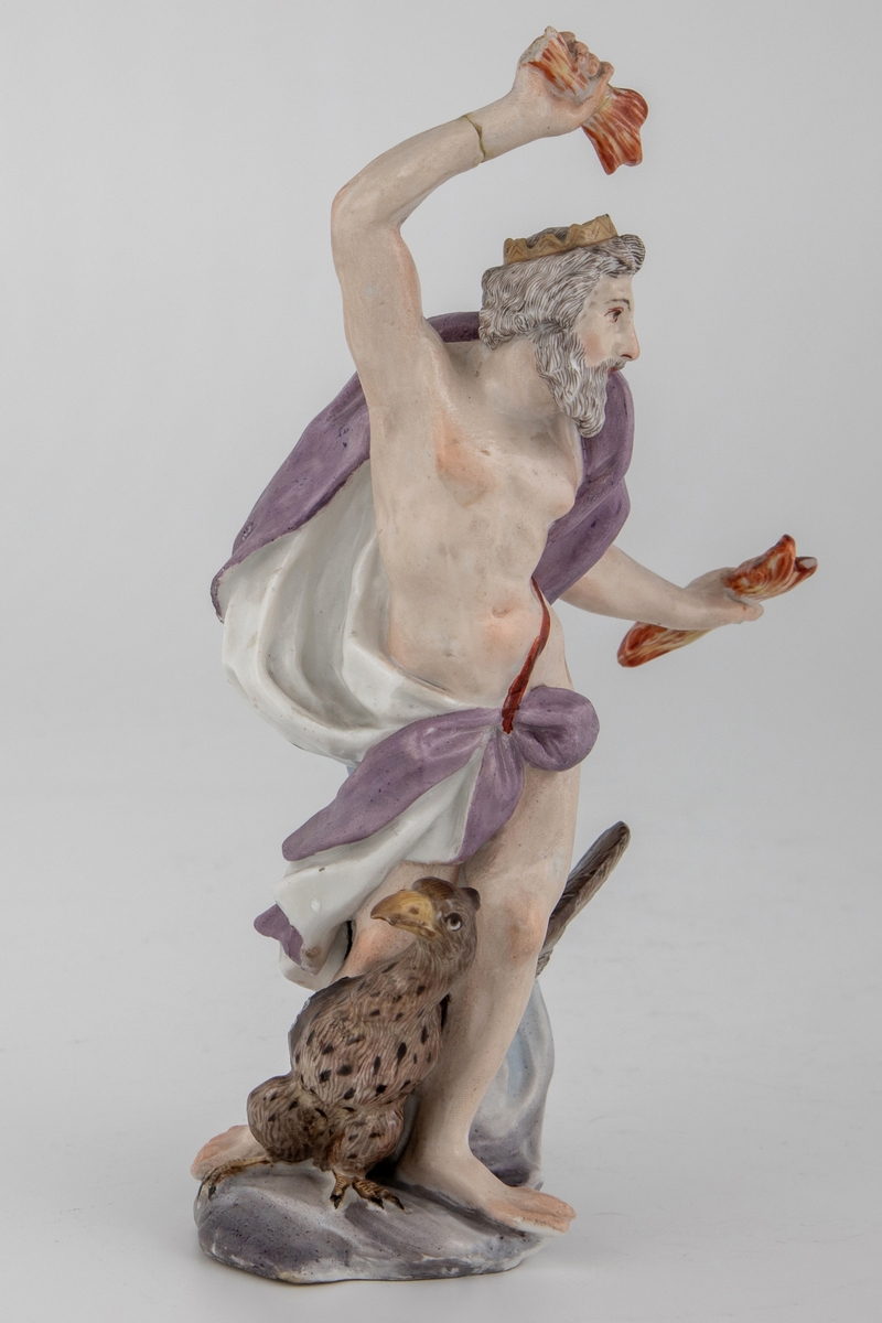 Figur av skjegget mann med ørn og tordenkiler i hendene, som skal forestille Jupiter/Zevs. Hvitglasert porselen med polykrom overglasurmaling. Han er iført et hvitt og lilla draperi, mens på hodet har han en tagget krone. Armene er hevet og han er fremstilt i det pregnante øyeblikk før han skal kaste tordenkilene.