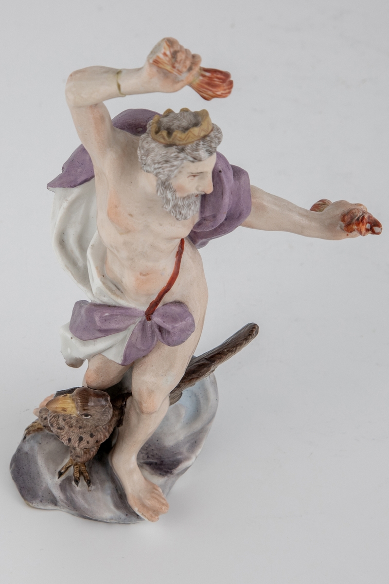 Figur av skjegget mann med ørn og tordenkiler i hendene, som skal forestille Jupiter/Zevs. Hvitglasert porselen med polykrom overglasurmaling. Han er iført et hvitt og lilla draperi, mens på hodet har han en tagget krone. Armene er hevet og han er fremstilt i det pregnante øyeblikk før han skal kaste tordenkilene.