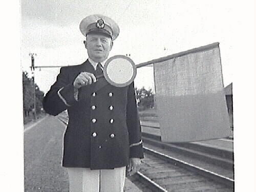 Bilder från stationsmästare Lindahls avgång. Bild G28511: fr v (som man ser dem på fotot) Hans Emil Drews, f 1919-03-19, Lennart Alexander Roos, f 1922-09-24, Ernst Kullgraf, Verner Svensson, Nils Allan Evert Bäckman, f 1923-09-20 i Träslöv, Carl Nestor Reinhold Lindahl, f 1887-08-23 i Revsunds församling, Gösta Larsson och Algot Bengtsson. Bild G28514 avgående stationsmästaren Lindahl mottager avskedsgåvan som var en tallrik med Tvååkers station ingraverad. Gåvan överlämnades av Hans Emil Drew, f 1919-03-19, i Halmstad, anställd vid SJ 1938.