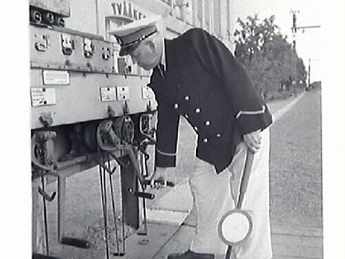 Bilder från stationsmästare Lindahls avgång. Bild G28511: fr v (som man ser dem på fotot) Hans Emil Drews, f 1919-03-19, Lennart Alexander Roos, f 1922-09-24, Ernst Kullgraf, Verner Svensson, Nils Allan Evert Bäckman, f 1923-09-20 i Träslöv, Carl Nestor Reinhold Lindahl, f 1887-08-23 i Revsunds församling, Gösta Larsson och Algot Bengtsson. Bild G28514 avgående stationsmästaren Lindahl mottager avskedsgåvan som var en tallrik med Tvååkers station ingraverad. Gåvan överlämnades av Hans Emil Drew, f 1919-03-19, i Halmstad, anställd vid SJ 1938.