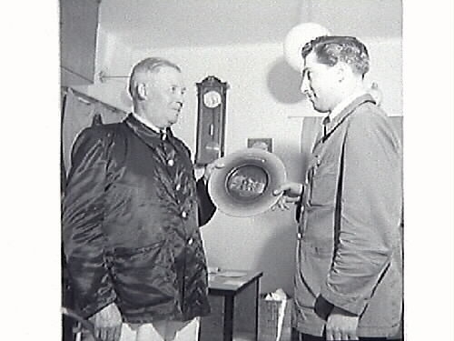 Bilder från stationsmästare Lindahls avgång. Bild G28511: fr v (som man ser dem på fotot) Hans Emil Drews, f 1919-03-19, Lennart Alexander Roos, f 1922-09-24, Ernst Kullgraf, Verner Svensson, Nils Allan Evert Bäckman, f 1923-09-20 i Träslöv, Carl Nestor Reinhold Lindahl, f 1887-08-23 i Revsunds församling, Gösta Larsson och Algot Bengtsson. Bild G28514 avgående stationsmästaren Lindahl mottager avskedsgåvan som var en tallrik med Tvååkers station ingraverad. Gåvan överlämnades av Hans Emil Drew, f 1919-03-19, i Halmstad, anställd vid SJ 1938.