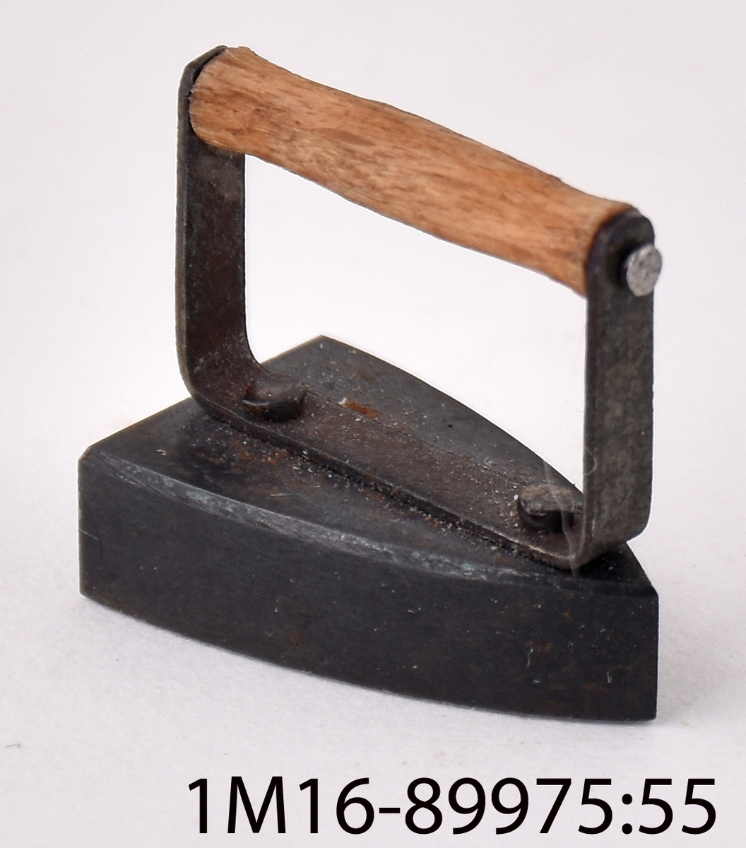 Strykjärn av metall med trähandtag, för dockskåp.