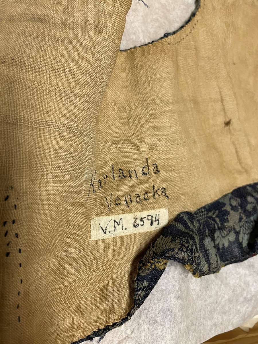 Till kvinnodräkt; brokad, grå-grön.