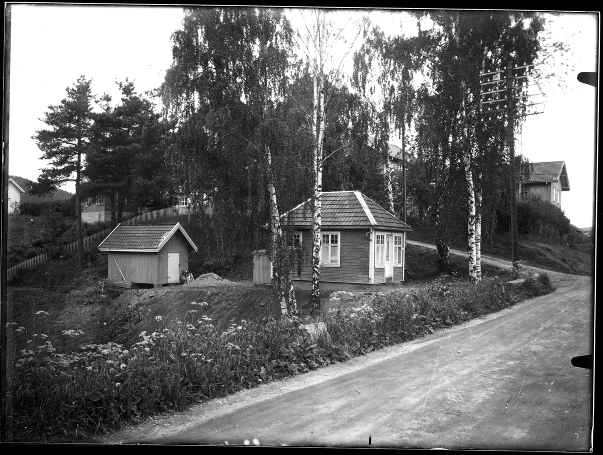 Et lite hus eller bu. Sett fra to forskjellige vinkler. Vanntårn for jernbane på det ene bildet.