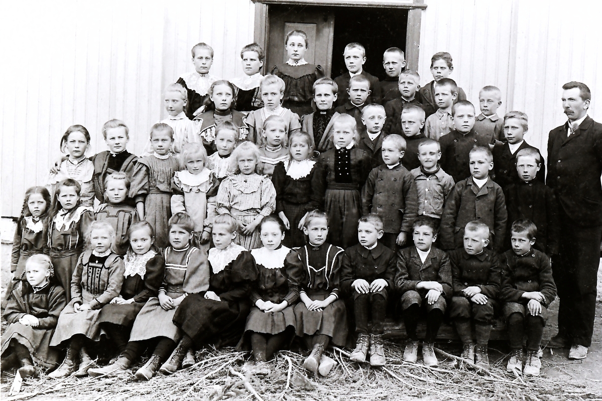 Lærer Martin Øydvin f. 1878 med skolens elever. Nr.1 første rekke fra venstre er Gina Margrethe Olsdatter Hvam