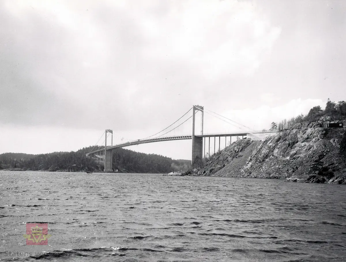 Bygging av Tromøybrua 1959-1961. 
Bilde viser Tromøybrua 1961. Ferdig bru fotografert mot Tromøy, fra Dyvika.
Hengebru med fagverk, ingen opphengte sidespenn. Lengde 400,30 meter. 
Kilde: Statens vegvesen sitt bruregister "Brutus". 

Jf. bilder NVM 09-F-00331-00364 og NVM 09-F-00722-00744.