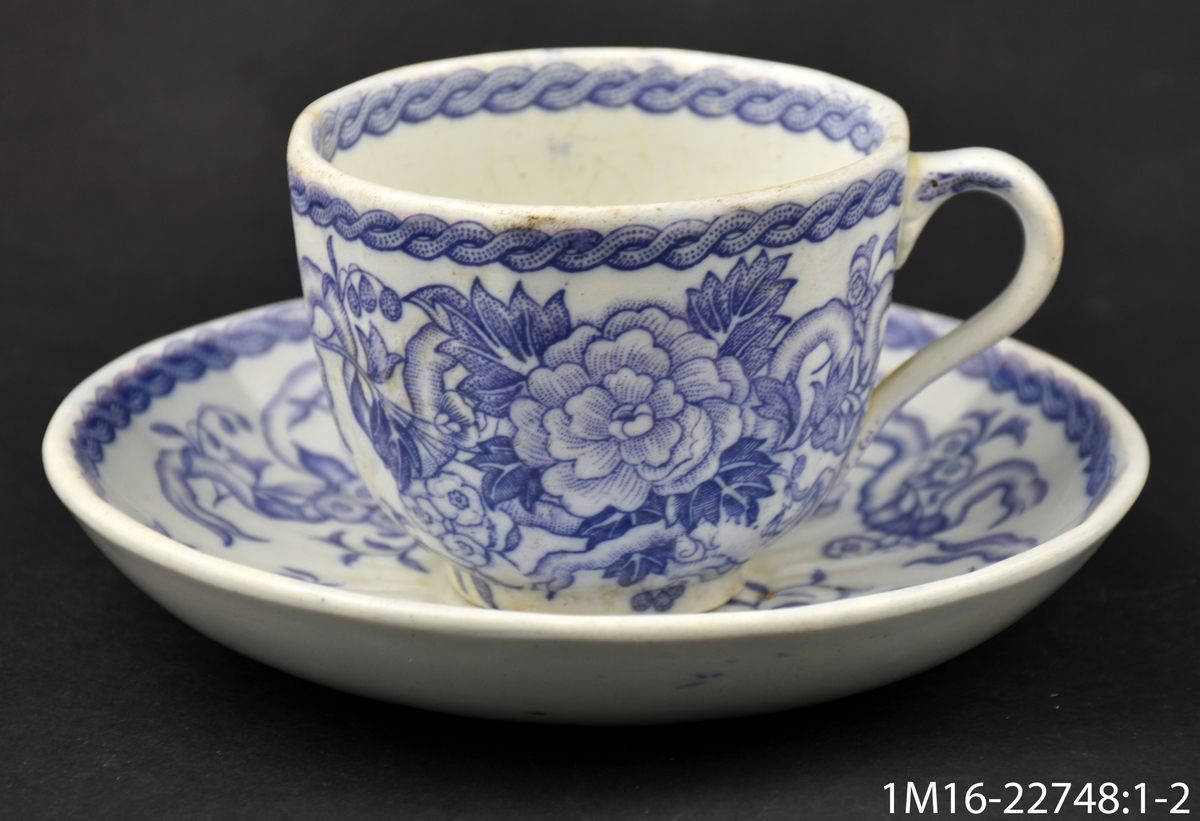 Kaffekopp med stora blommor i ljus lila, i botten av koppen IX (eller XI), i botten av fatet Lilas  (dekornamnet) inom blomkrans, inpressat Rörstrand. Ironstone.
