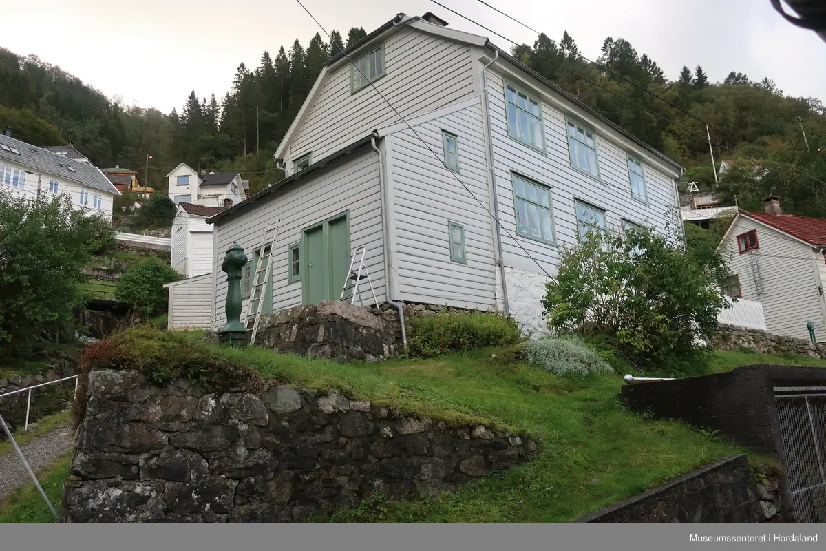 Den første arbeidarbustaden til Salhus Tricotagefabrik (1859-1989), bygd året etter fabrikken. Opphavleg inndelt i seks leilegheiter og sovesalar.