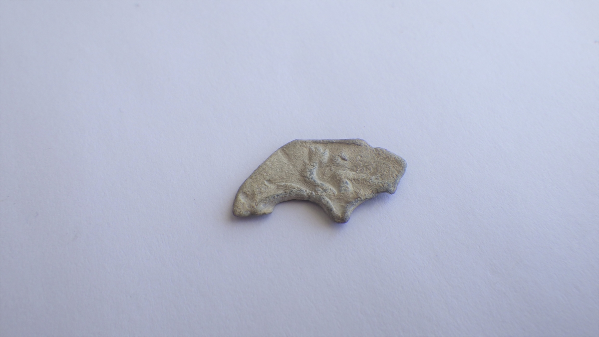 Deler av et stående løveliknende fabeldyr, vendt mot venstre. 