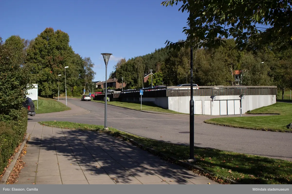 Parkeringsgarage i anslutning till bostadsbebyggelsen i Smörkullegården, Lindome, den 4 oktober 2016. I bakgrunden ses även ett par bostadshus vid Gråstensvägen. Vy mot nordost.