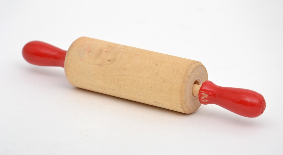 Bakeleketøy bestående av et kjevle i tre, fire ulike plastpepperkakeformer i forskjellige farger, en melskuffe i plast og ei paiform i metall