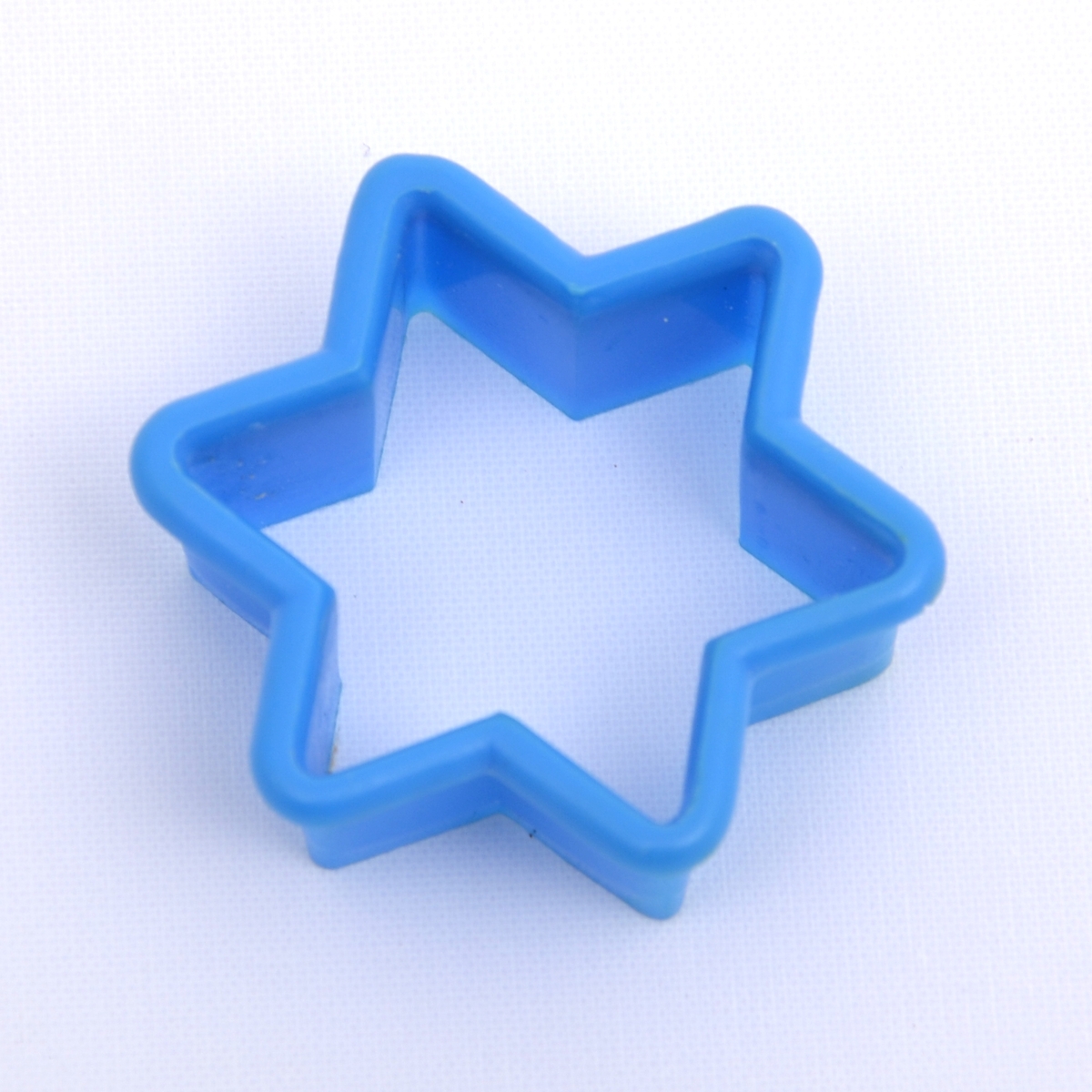 Bakeleketøy bestående av et kjevle i tre, fire ulike plastpepperkakeformer i forskjellige farger, en melskuffe i plast og ei paiform i metall