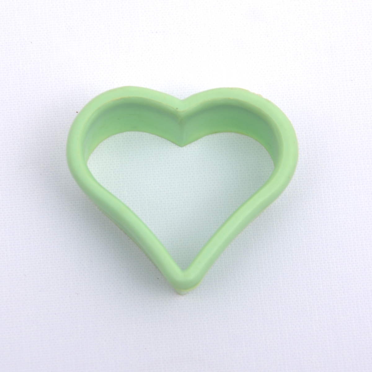 Bakeleketøy bestående av et kjevle i tre, fire ulike plastpepperkakeformer i forskjellige farger, en melskuffe i plast og ei paiform i metall