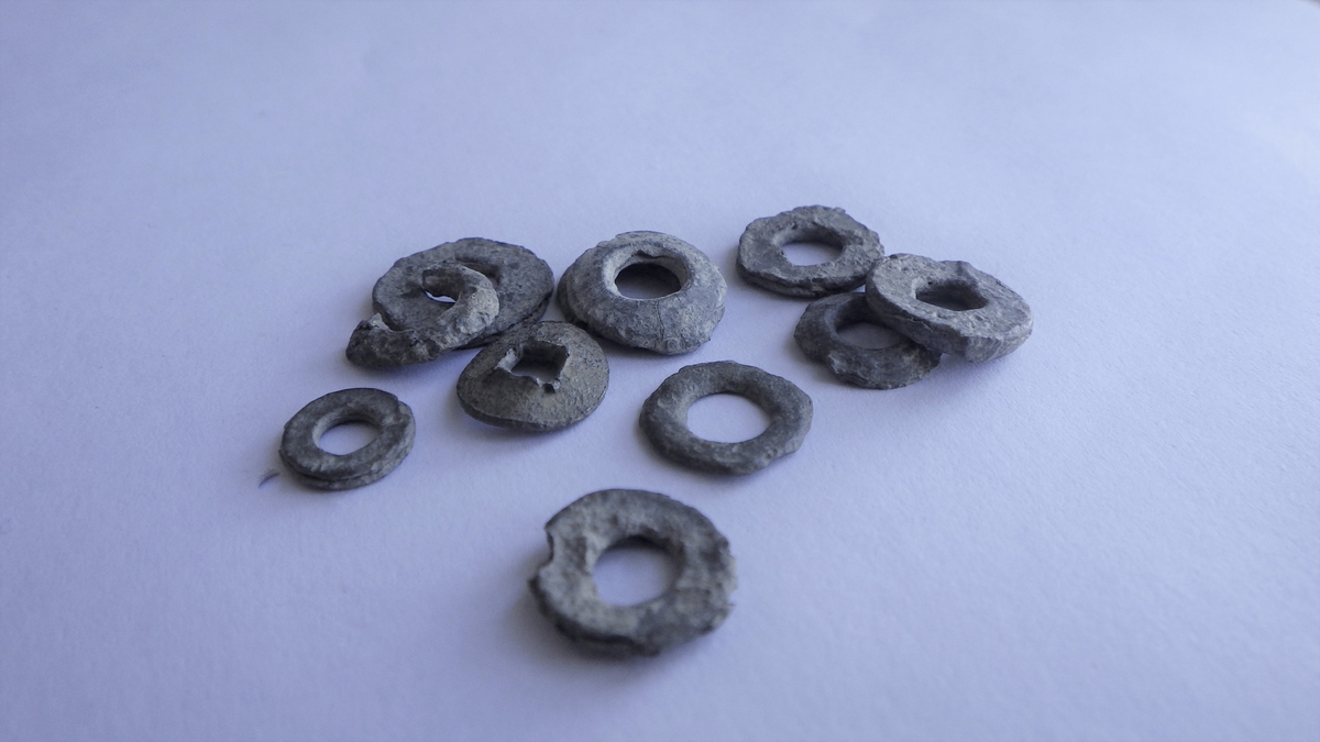 MALV: DIAM. 8-10 MM, RUND SKIVE MED HULL I. HULLENE SYNES FOR STORE TILÅ VÆRE ROPLATER. LIGGER SAMMEN MED MALJENE. 