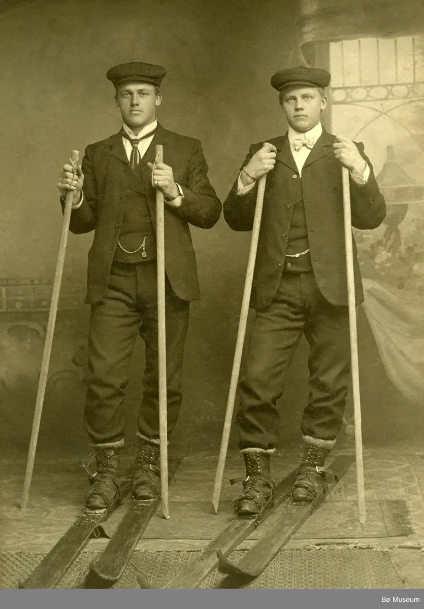 Helland Brothers, Knut G. Helland t.v. og Gunnar G. Helland t.h. på ski inne i eit fotoatelier.