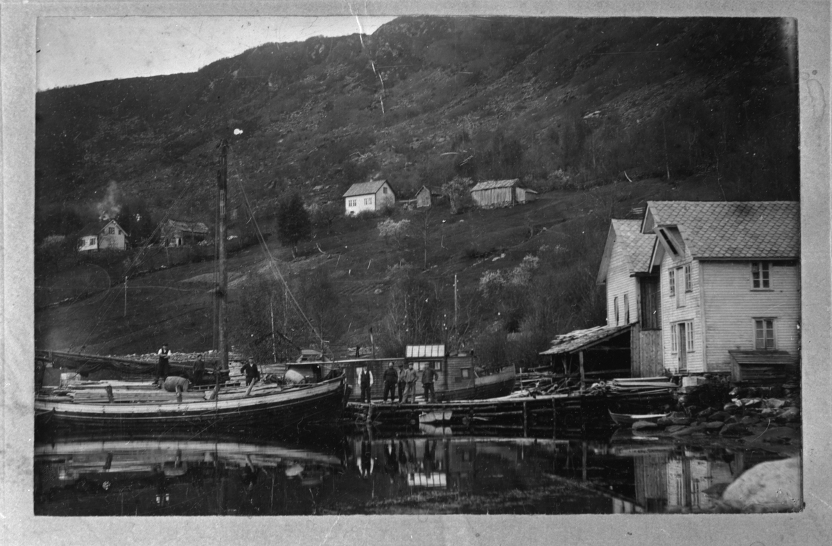 Kaien ved Berge Sag og Trelastforetning, 1915. Bak kaien ligg husbåten "Flyda-Dell". Den tilhøyrde "Elavakongen" (O. M. Ramsø), som reiste rundt i bygdene og fotograferte.