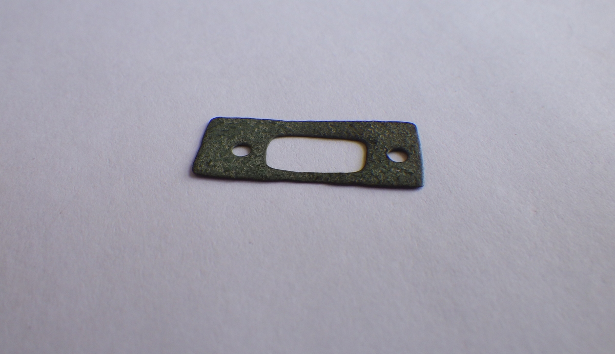 MALV: 22, 9 MM, BÅNDFORMET, KLIPPET ELLER STANSET UT AV METALLBÅND. ET REKTANGULÆRT OG TO RUNDE HULL. 