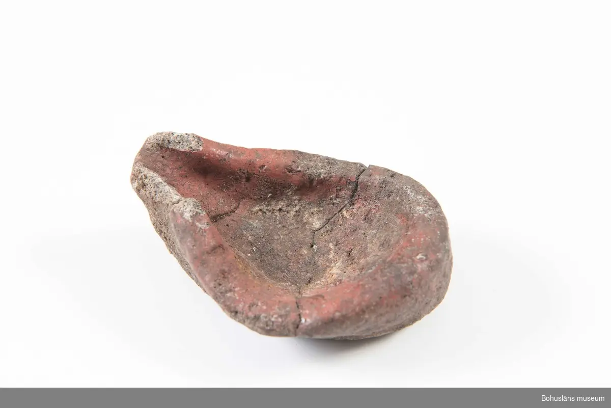 En hel komplett degel (sammansatt av två delar) och ett femtiotal fragment. Delvis rödaktig sintrad yta. Ljusgrått hårbränt kompakt gods. Delvis sintrade ytor. Degeln använd vid gjutning av bronsföremål.

294 Landskap BOHUSLÄN
