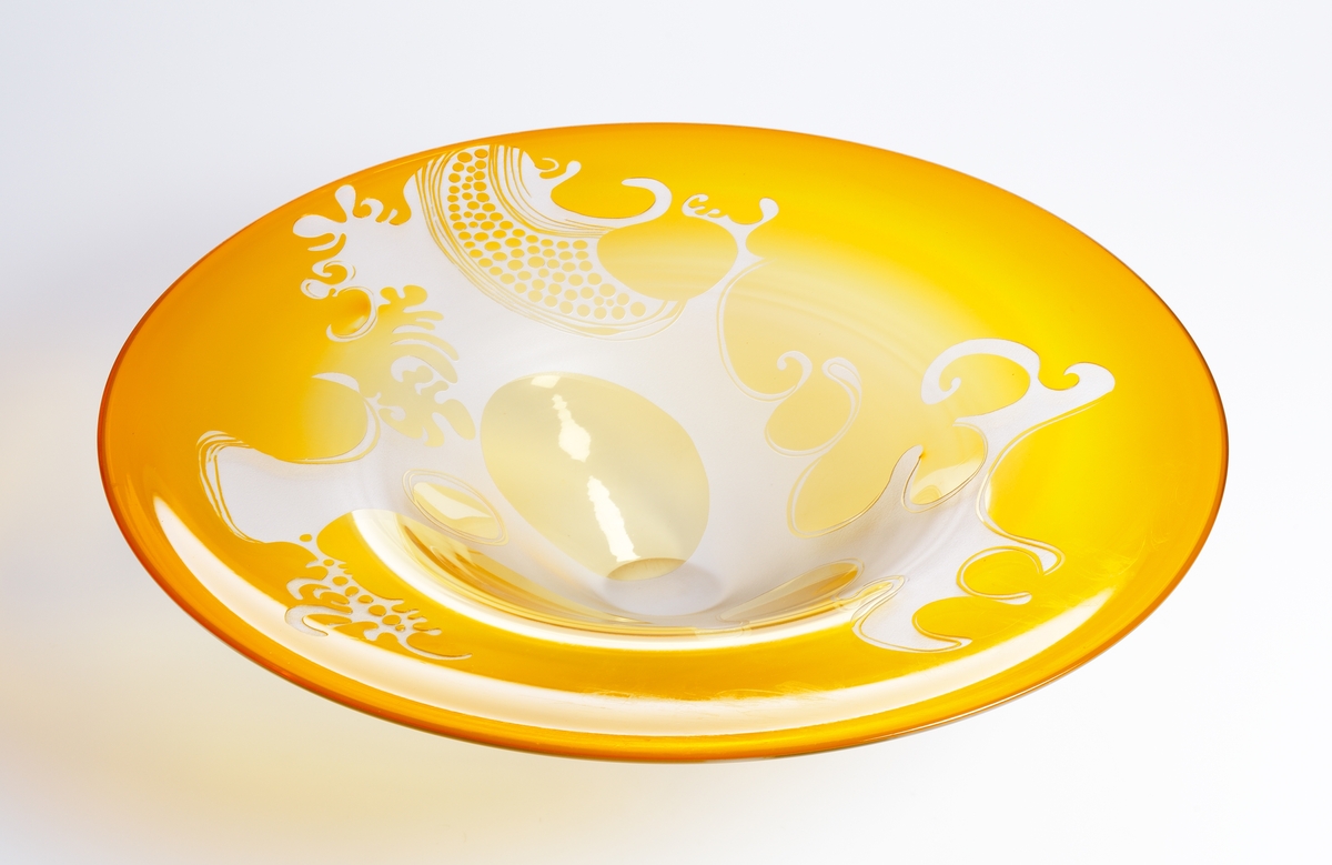 Fat/prydnadsföremål.
Väldigt stort, gult underfång som blästrats genom till klarglaset.
Ett "organiskt" mönster.
Funktion: Fat/prydnadsföremål