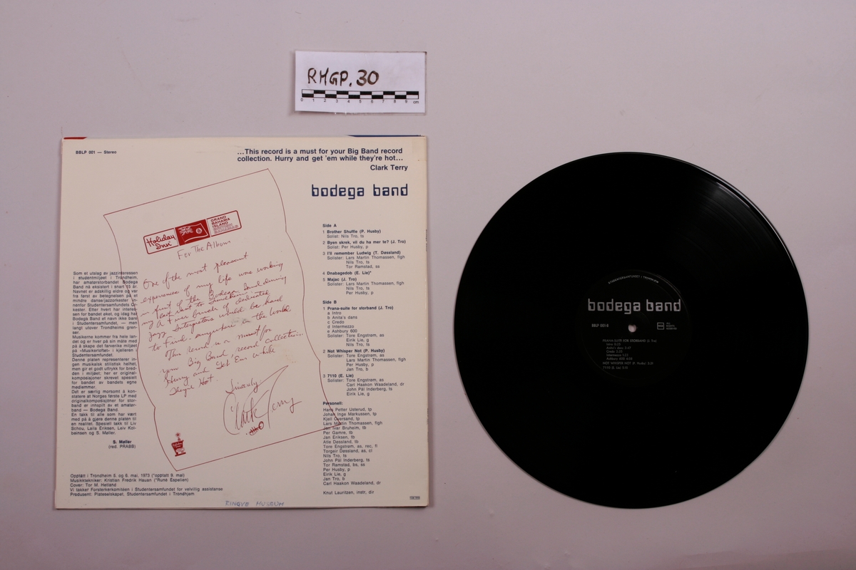 Grammofonplate i svart vinyl og plateomslag i papp. Plata ligger i en papirlomme.
