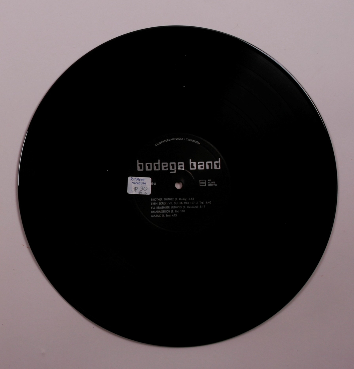 Grammofonplate i svart vinyl og plateomslag i papp. Plata ligger i en papirlomme.
