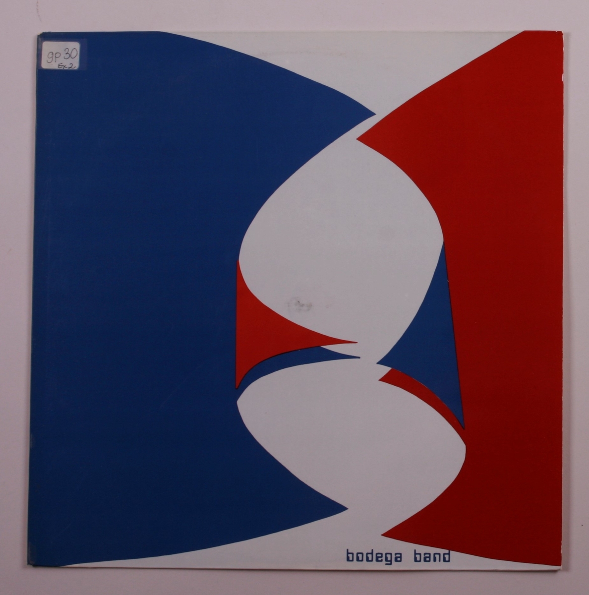 Grammofonplate i svart vinyl og plateomslag i papp. Plata ligger i en papirlomme.
