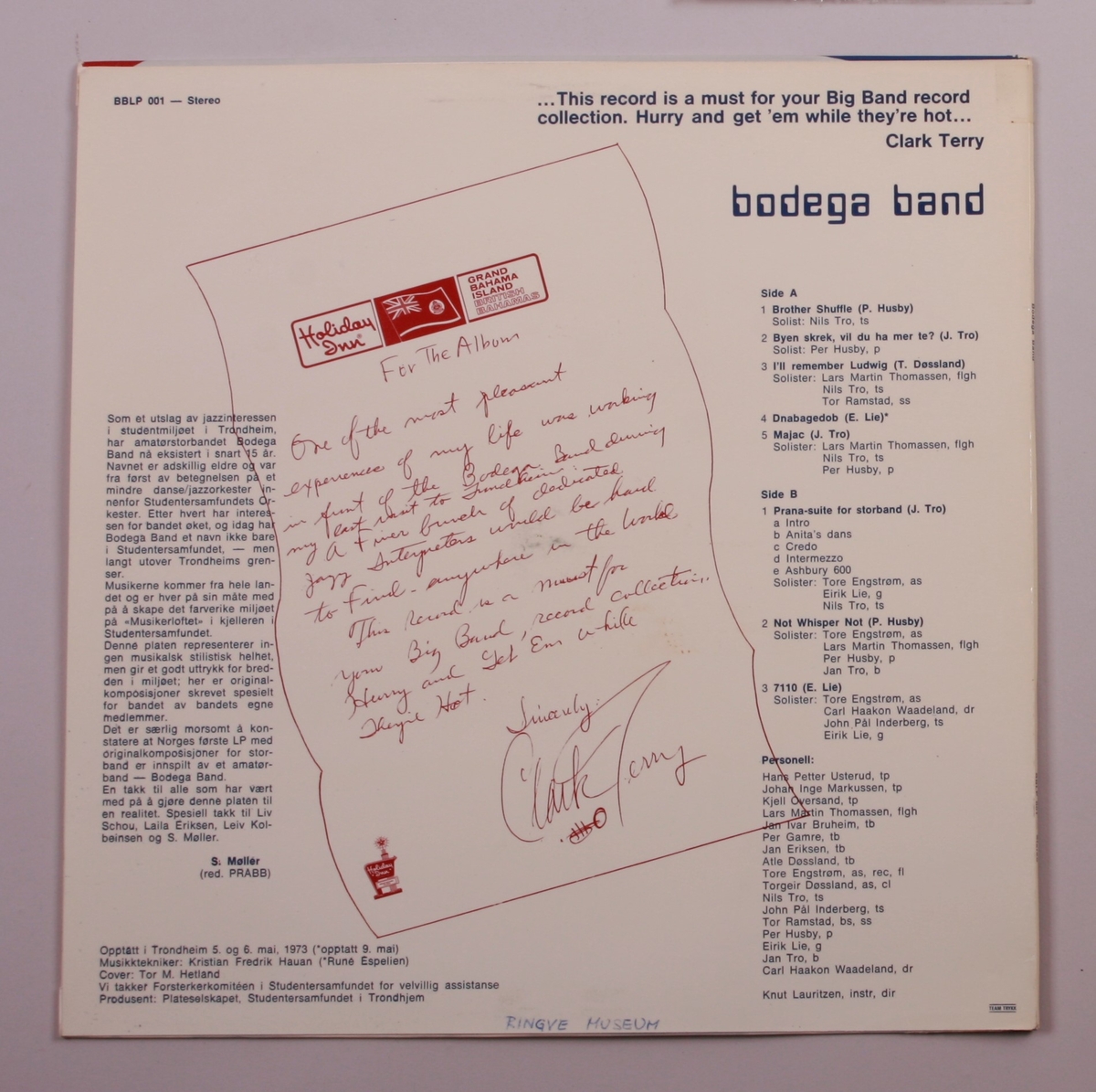 Grammofonplate i svart vinyl og plateomslag i papp. Plata ligger i en papirlomme.
