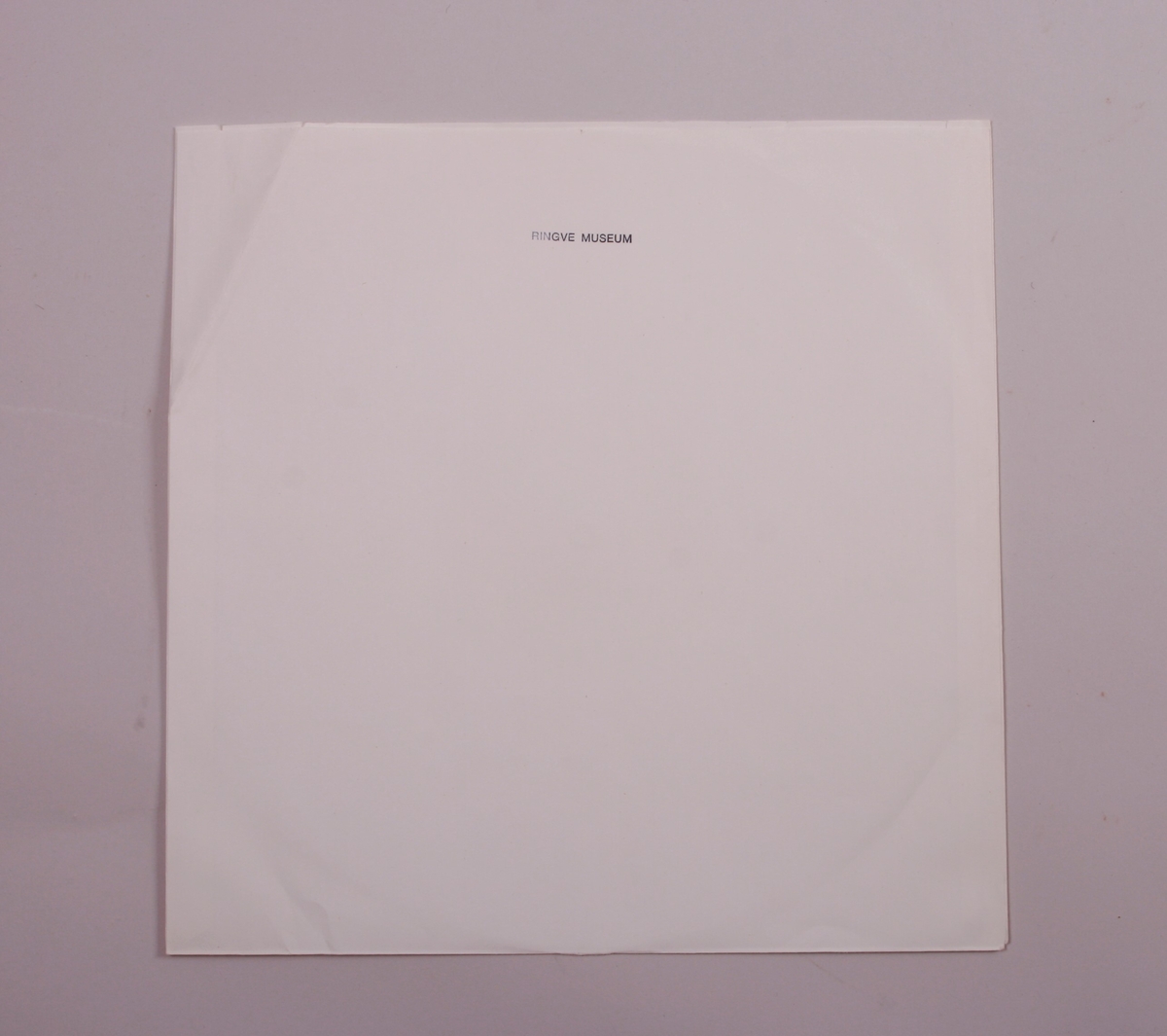 Grammofonplate i svart vinyl og plateomslag i papp. Plata ligger i en papirlomme.
