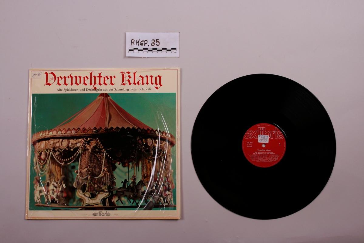 Grammofonplate i svart vinyl og plateomslag i papp. Plata ligger i en papirlomme.