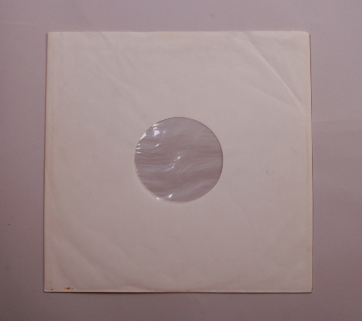 Grammofonplate i svart vinyl og plateomslag i papp. Plata ligger i en papirlomme.