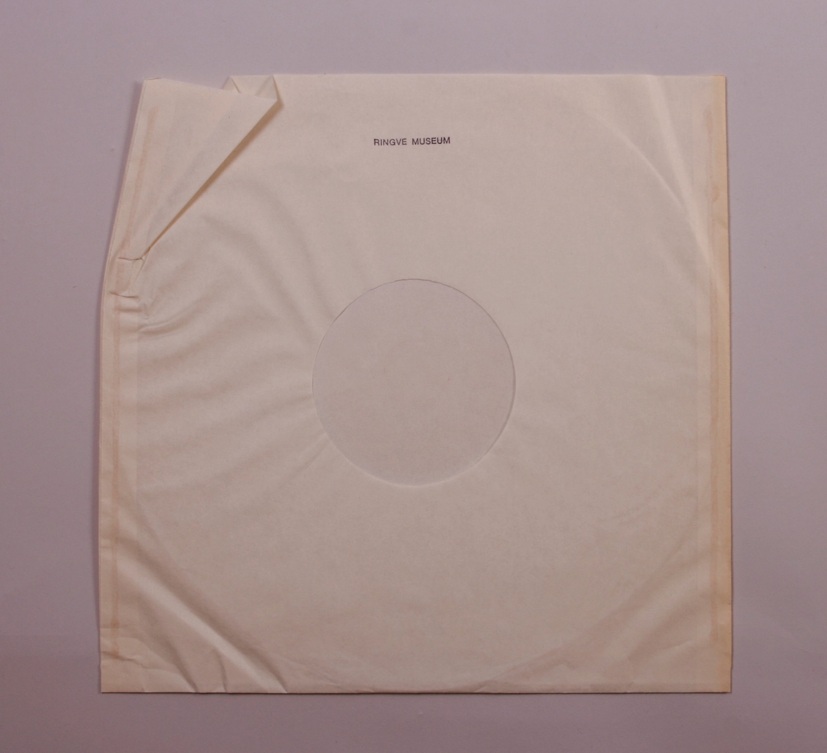 Grammofonplate i svart vinyl og plateomslag i papp. Plata ligger i en papirlomme.