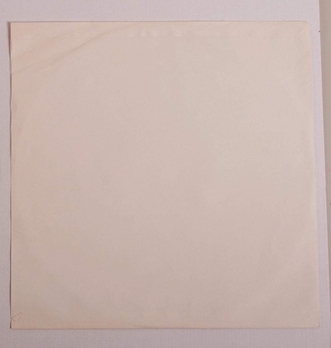 Grammofonplate i svart vinyl og plateomslag i papp. Plata ligger i en papirlomme.