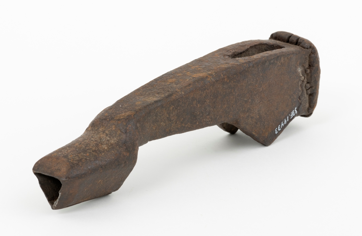Merkeøks uten skaft, men med litt uvanlig form. Øksehodet er 18,4 centimeter høyt, målt fra eggen til nakken. Det er formet som ei lita hakke, der merkedelen, ei 4,0 til 4,5 centimeter høy kon hylse med triangulært tverrsnitt er utsmidd i den ytre enden. Eggen er fasfilt. Øksehodet tiltar i bredde fra merkedelen mot nakken. «Kjakene» som omgir øyet (skafthullet) er noe forlenget med fliker på den sida som vente mot øksebrukeren, en løsning som antakelig skulle stabilisere skjeftinga. Øksa har en uvanlig kraftig, massiv nakke som bærer preg av å ha vært hamret på. Nakken er 4,6 centimeter lang og 3,5 centimeter bred. Øksehodet veier 826 gram.