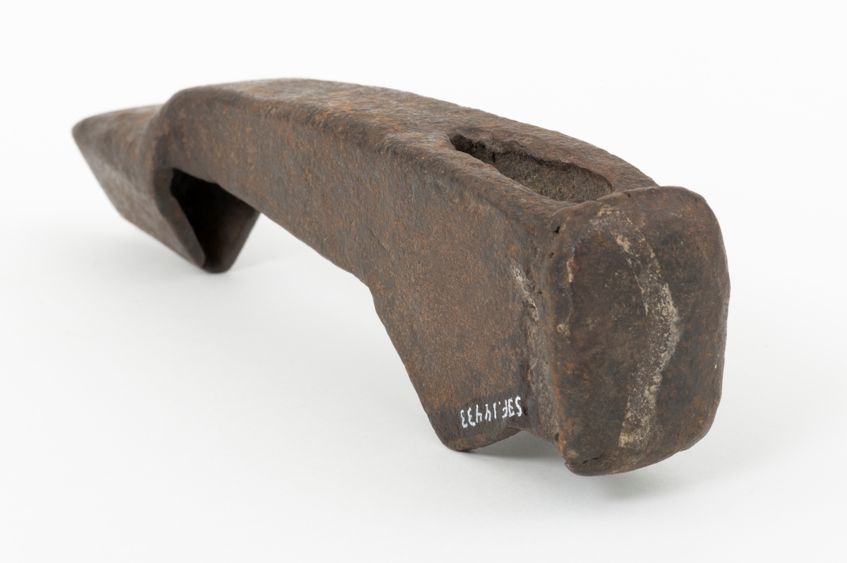 Merkeøks uten skaft, men med litt uvanlig form. Øksehodet er 18,4 centimeter høyt, målt fra eggen til nakken. Det er formet som ei lita hakke, der merkedelen, ei 4,0 til 4,5 centimeter høy kon hylse med triangulært tverrsnitt er utsmidd i den ytre enden. Eggen er fasfilt. Øksehodet tiltar i bredde fra merkedelen mot nakken. «Kjakene» som omgir øyet (skafthullet) er noe forlenget med fliker på den sida som vente mot øksebrukeren, en løsning som antakelig skulle stabilisere skjeftinga. Øksa har en uvanlig kraftig, massiv nakke som bærer preg av å ha vært hamret på. Nakken er 4,6 centimeter lang og 3,5 centimeter bred. Øksehodet veier 826 gram.