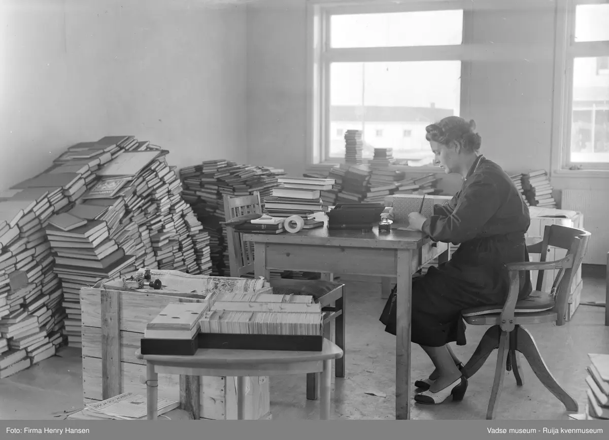 Vadsø rådhus, interiør fra biblioteket som hadde lokaler i sokkeletasjen 1952-1964. Sjefsbibliotekar Birgit Kubberud Frette ved skrivebordet. Rådhuset ble bygd i 1951-1952.