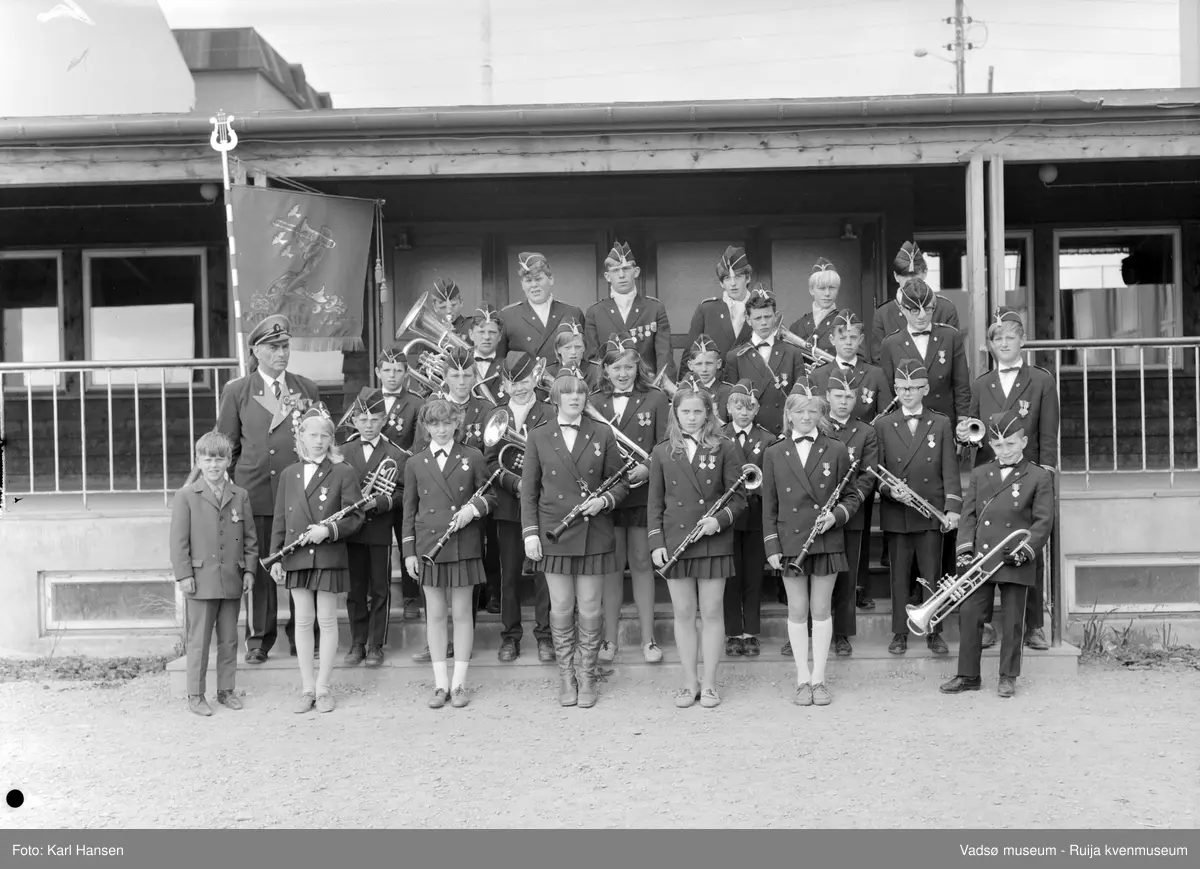Vardø guttemusikkorps ved inngangen på Sentrum skole i Vadsø 30.juni 1969. På bildet er det både gutter og jenter blant korpsmedlemmene. 