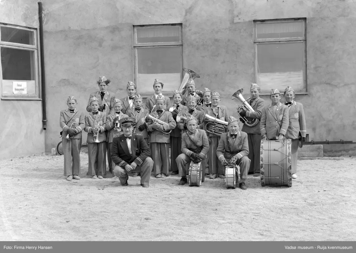 Vadsø  mai 1951. Vadsø Guttemusikkorps  og dirigent fotografert på torget  i Vadsø. Dirigent; Olav L. Holmen.
