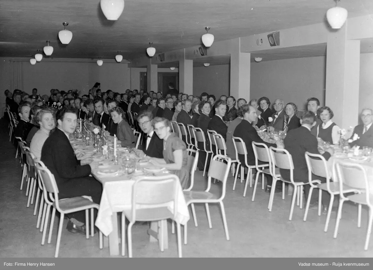 Gruppebilde  på Vadsø folkeskole 1956, festmiddag. Bildet er trolig tatt ved innvielsesfesten for Vadsø folke- og framhaldsskole 28.10.1956. Kilde: Melding om Vadsø folke- og framhaldsskole for skoleårene 1951/52-1959/1960. Vadsø 1962.
