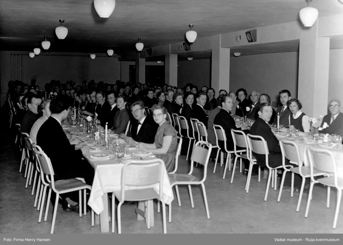 Gruppebilde på Vadsø folkeskole, festmiddag.  Bildet er trolig tatt ved innvielsesfesten for Vadsø folke- og framhaldsskole 28.10.1956. Kilde: Melding om Vadsø folke- og framhaldsskole for skoleårene 1951/52-1959/1960. Vadsø 1962.