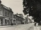 Kungsgatan, Växjö, mot nordväst, 1920. 
Man ser husen i kvarteret Unaman och Sunaman. Till vänster järnhandlare Sven Johan Johanssons fastighet, sedan Schanderska fastigheten (där operasångerskan Christina Nilsson disponerade några rum på tredje våningen under många år) och därefter den s.k. P.N. Perssons hörna, följd av Skånska bankens fastighet.