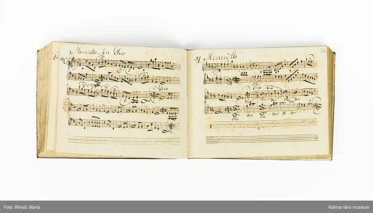 KLM 21071. Notbok, handskrift. Tvärformat. Helt skinnband med marmorering samt guldpräglade dekorelement. På pärmens framsida: VIOLINO PRIMO. På försättsbladet: I:N:J:C. samt Adam Lorentz Stålhammar ao 1773. Därefter handskrivna kompositioner, menuetter.