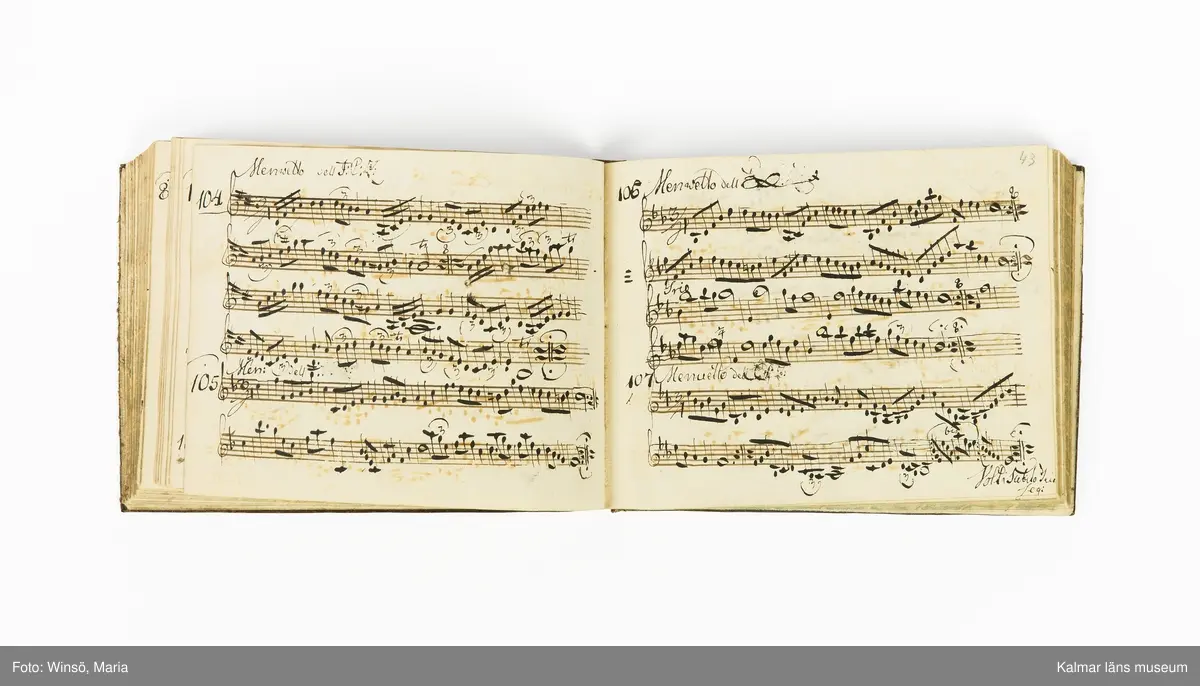 KLM 21071. Notbok, handskrift. Tvärformat. Helt skinnband med marmorering samt guldpräglade dekorelement. På pärmens framsida: VIOLINO PRIMO. På försättsbladet: I:N:J:C. samt Adam Lorentz Stålhammar ao 1773. Därefter handskrivna kompositioner, menuetter.