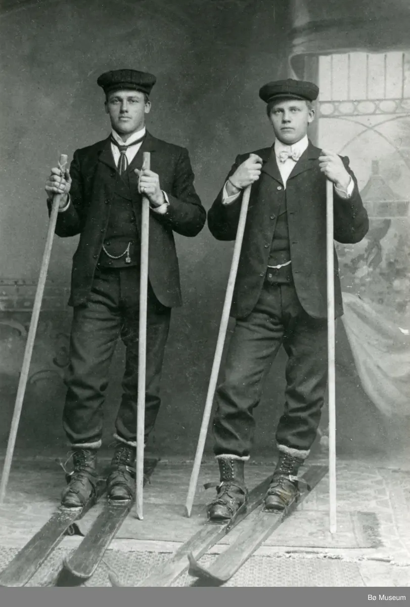 Helland Brothers, Knut G. Helland t.v. og Gunnar G. Helland t.h. på ski inne i eit fotoatelier.
