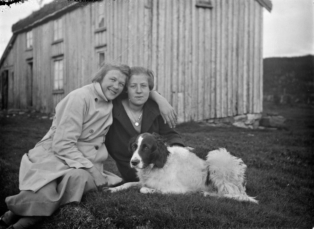 Leirfjord, Ulvangen, Myrvang. Gammelhuset på Myrvang i bakgrunnen. Foran sitter to damer som er ukjente. Hundens navn er ukjent.