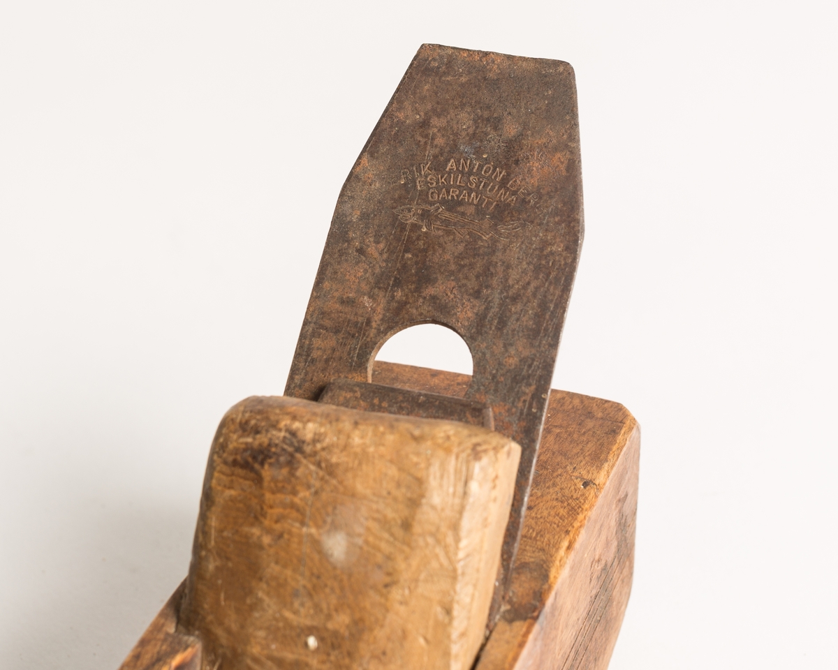 Buehøvel med høvelstål, klaff (sponbryter) og kile. Høvelstokken har buet såle og tre paralelle dekorstreker risset inn langs begge sidene. Et lengre felt av sålen er innfelt med et stykke hardere treverk (eik/nøttetre?). Oljet.