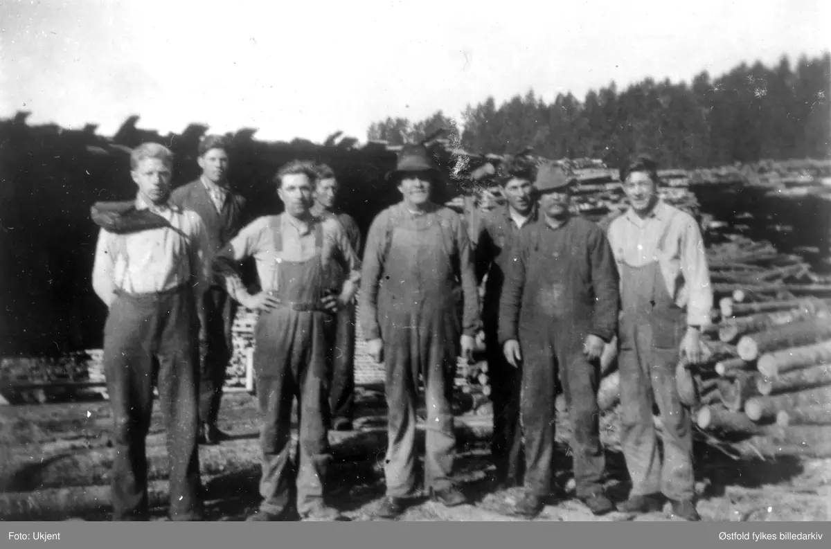 Sagmannskap på Belsby sag i Varteig 1935. Fra venstre: Bjørgan Belsby, John Belsby, Arve Lunde, Edvard Nilsen,    Sandberg, Sverre Lunde, Erik Larsen, Sverre Belsby. Bjørgan har plankebærerpute.