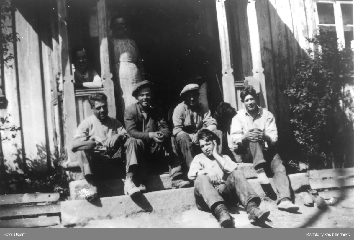 Middagshvil i våronna på Belsby i Varteig 1935. Fra venstre: Jens Belsby, NN, Lars Brusevold, Sverre Belsby. Gutten foran er Åsmund Arntsen. Stående kvinne bak er Helga Belsby.