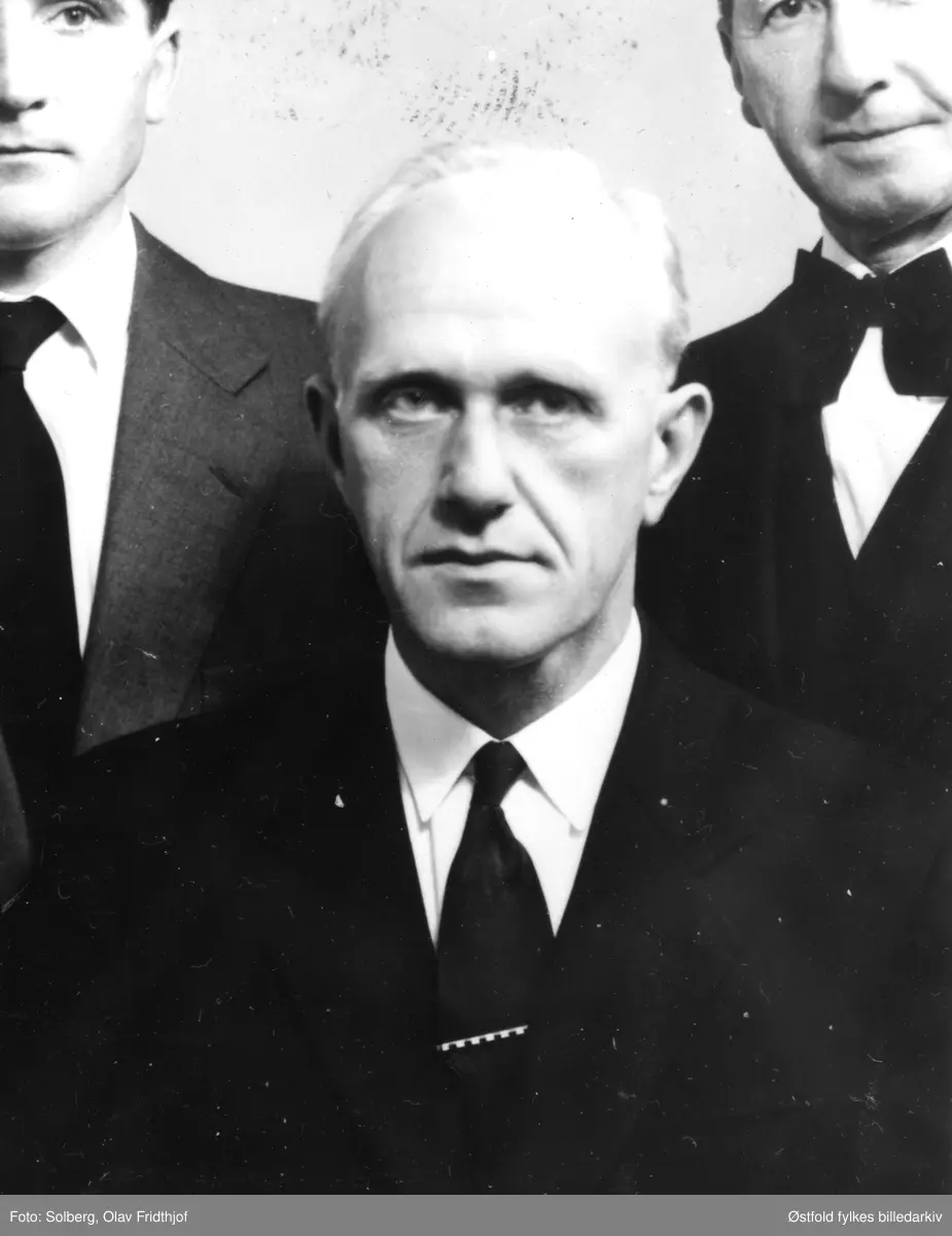 Portrett (utsnitt av gruppebilde) av John Myrås. Myrås var herredskasserer i Varteig fra 1945-54, ligningssjef fra 1956-76, Forsyningsnemda 1940, klokker fra 1956-79.