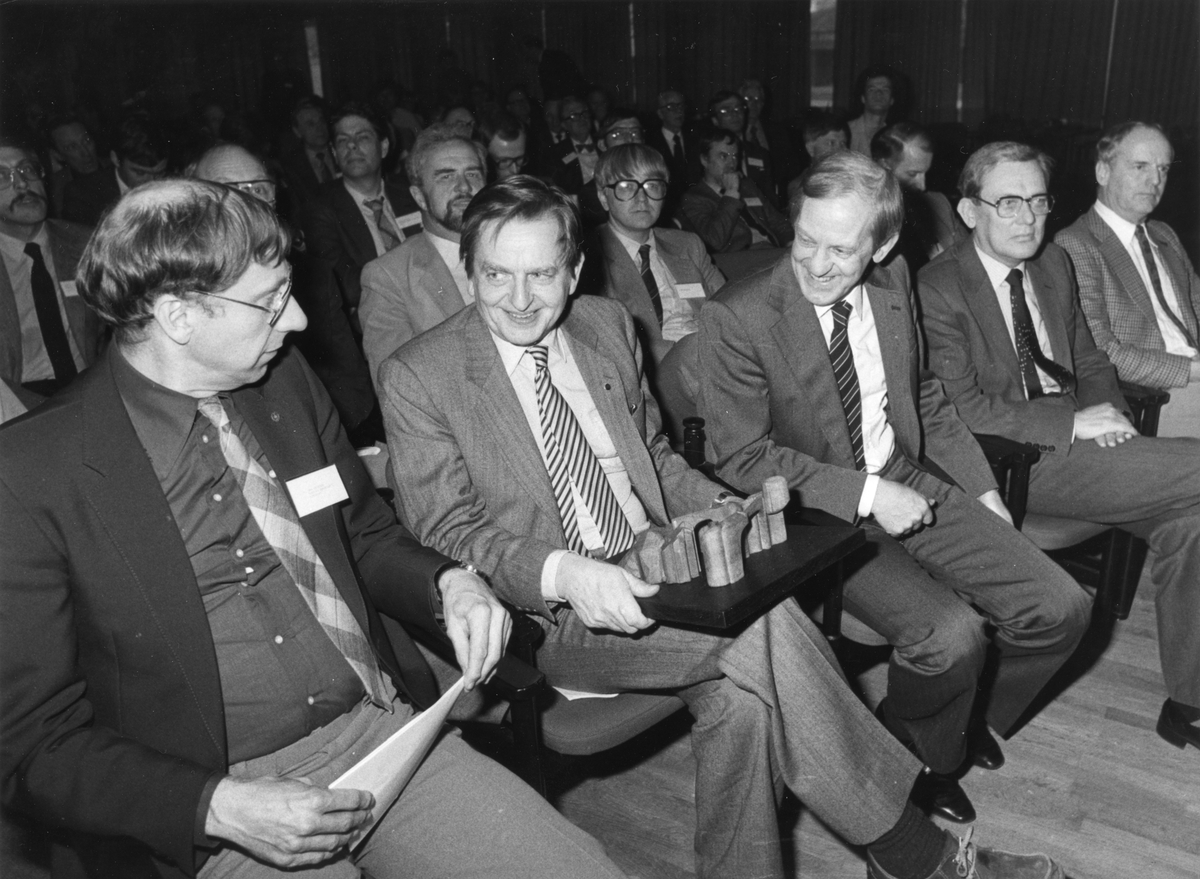 Bild i Cupolen under Tekniska Träffen i Linköping den 17-18 mars 1983. Människor sitter i en aula eller liknande. I mitten sitter Olof Palme.