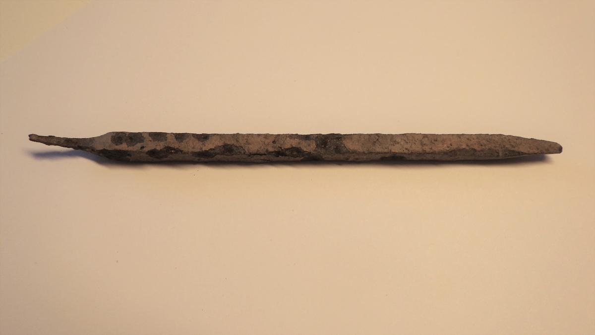 MALV: L. 17 CM, B. 0, 5 CM, AVLANG, KVADRATISK TVERRSNITT, TO MOTSTÅENDE HJØRNERI KVADRATET ER HAMRET INN RETT FØR OVERGANGEN TIL SELVE SPISSEN. KORTTANGE. SIGURD GRIEG, MA. BYFUND, FIG. 280. 